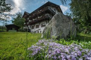 瓦尔腾斯堡昂可立瓦酒店的一座大石头和紫色花的房子