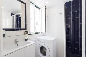 里斯本阿尔法玛中心公寓的白色的浴室设有洗衣机和水槽。