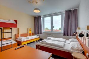 汉堡翰堡城中心梅尼奈格酒店的客房设有两张床、一张桌子和一张书桌。