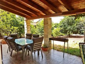 达夫纳Huge & Private Villa In Kibbutz Dafna的天井配有桌椅和钢琴。