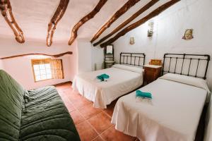 Castillo de LocubínCortijo Rural Majolero的一间带两张床和一张沙发的卧室
