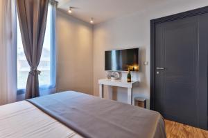 波德戈里察M酒店的一间卧室设有一张床、一台电视和一个窗口。