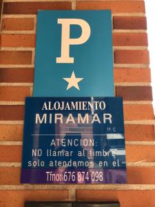 桑托尼亚Alojamiento Miramar的砖墙边的标志