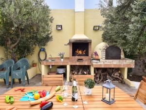 因赫尼奥Belvilla by OYO Algodones 4 pax的庭院设有壁炉和带蔬菜的桌子。