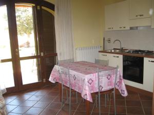 福洛尼卡甜蜜科里纳农家乐的厨房配有一张桌子,上面有粉红色的桌布