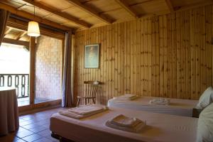 图里恩奥Albergue La Cabaña的客房设有两张床、一把椅子和窗户。