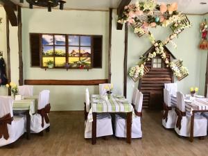 Horodets'ke迷你格特尔波兹提酒店的墙上设有带桌椅和鲜花的用餐室
