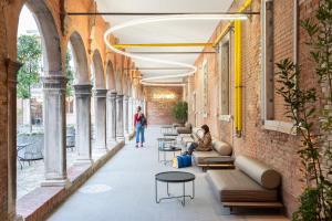 威尼斯Combo Venezia的大楼内带长椅和桌子的走廊