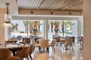 恩波其克Herbert Samuel Milos Dead Sea的餐厅设有桌椅和大窗户。