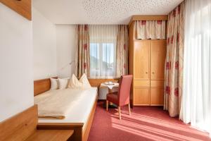 巴特霍夫加施泰因阿尔本霍夫酒店的酒店的客房 - 带一张床、椅子和窗户