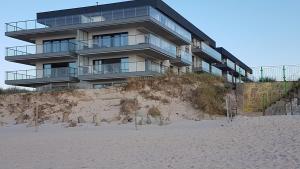 济夫努夫Apartament Fala Gardenia Seaside的坐落在沙滩顶上的建筑