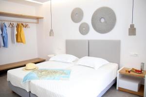 纳克索乔拉Casabella的卧室配有白色的床和帽子
