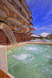 阿尔巴·阿德里亚蒂卡Almaluna Hotel & Resort的一座建筑前的带喷泉的游泳池