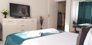 坎普朗莫道尼斯Luxury-Apartment Ultracentral的一间卧室配有一张床,梳妆台上配有电视