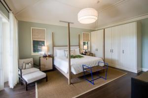 拿骚岛屿之家酒店的一间大卧室,配有一张床和一把椅子