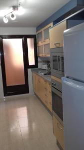 阿瓜杜尔塞Apartamento 3 Hab. en el Parador的厨房配有冰箱和炉灶。 顶部烤箱