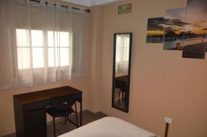 戈梅拉岛圣塞瓦斯蒂安Calle Real的一间卧室配有书桌和镜子