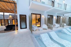 Sant Francesc de s'EstanyOM Hotels的一座带白色家具的游泳池的房子