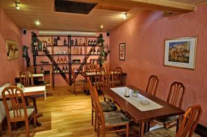 Sindringen奴斯旺酒店的餐厅设有桌椅和装有葡萄酒的架子