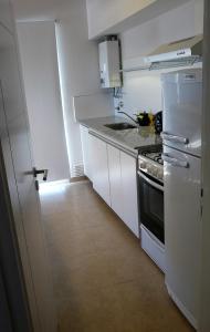 布兰卡港2 Confortable departamento con cochera para 2 a 4 pax的白色的厨房配有炉灶和冰箱。