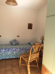 马萨Villa Poveromo的一间卧室配有一张床、一把椅子和一张书桌