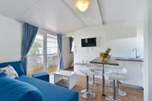图兰杰Mobile house Nord 2 Laguna的一间带蓝色沙发的客厅和一间厨房