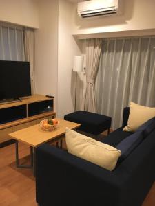 东京Oakwood Apartments Nishi-Shinjuku的客厅配有沙发和桌子