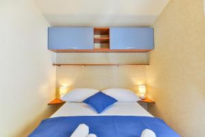图兰杰Mobile house 5 Laguna的一间卧室配有一张带两个蓝色枕头的床