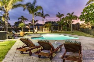泰帕Taipa Beach Resort的一个带2张躺椅的游泳池和一个游泳池