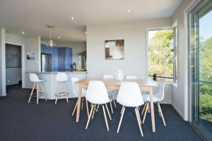 纳尔逊Selah Retreat的厨房以及带木桌和白色椅子的用餐室。