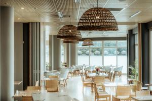 维拉港格兰德酒店及赌场的餐厅设有桌椅和大窗户。