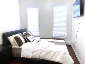 布鲁克林Rochester's Place的一间卧室配有带白色床单和枕头的床。