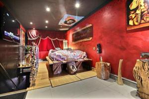 穆斯克龙古巴禅阿克提图德公寓的一间拥有红色墙壁的卧室和一张位于客房内的床
