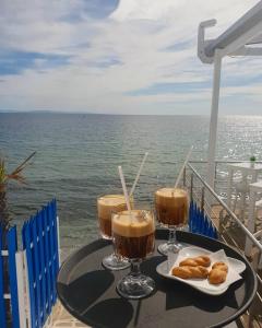 普拉卡利特索罗Olympos Beach的一张桌子,上面放着两杯饮料和一盘糕点