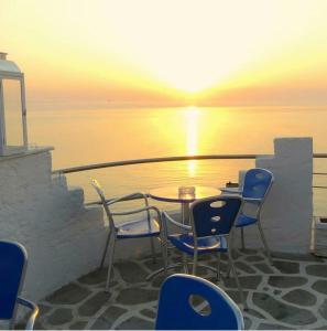 普拉卡利特索罗Olympos Beach的阳台上的桌椅享有日落美景
