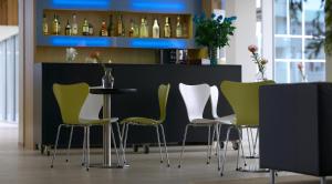 阿克雷里阿库雷里埃达酒店的酒吧配有绿色和白色的椅子和桌子