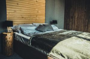 RzepiskaRzepiska Hills的一间卧室设有一张带木墙的大床