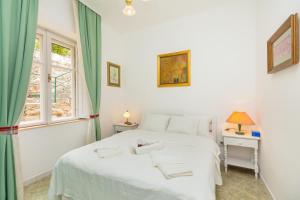 杜布罗夫尼克Apartment Villa Ahava的卧室配有白色的床和窗户。