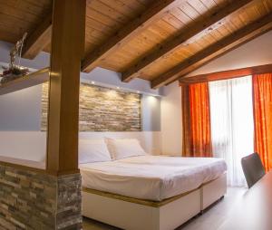 福尔加里亚Hotel Villaggio Nevada的一间卧室设有一张床和砖墙