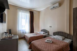 敖德萨Arnautskiy Hotel的酒店客房设有两张床和窗户。