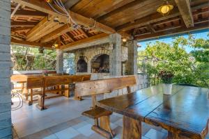 木洛希尼Apartmani Maris的户外庭院设有木桌和石制壁炉。
