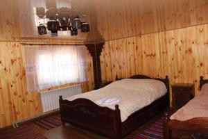 Vizhni SiniyvirКарпатське сяйво的一间卧室设有木镶板墙、一张床和一个窗口