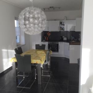 卡尔斯哈根DHH Claire_SAWO的厨房配有餐桌、椅子和吊灯。