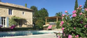 Senouillac乐瓦尔德拉加雷纳住宿加早餐旅馆的一座房子,在一座粉红色玫瑰的庭院里设有一个游泳池