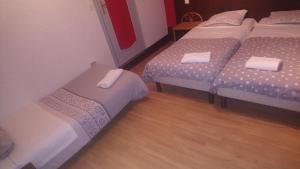 安锡萨沃酒店的客房设有三张床,铺有木地板。