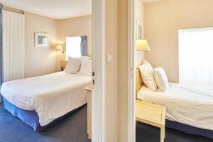 拉波勒卡罗琳别墅蓝色假日酒店的酒店客房设有两张床和窗户。