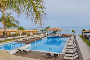 依克希亚Villa Di Mare Seaside Suites的一个带躺椅的游泳池,一个度假村