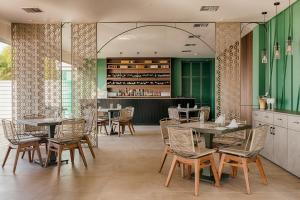 依克希亚Villa Di Mare Seaside Suites的一间带桌椅的餐厅和一间酒吧