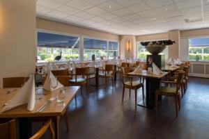 聚特芬聚特芬弗莱彻酒店的餐厅设有木桌、椅子和窗户。