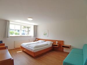 海利根港Apartment 5 - Maisonette的卧室配有床、椅子和窗户。